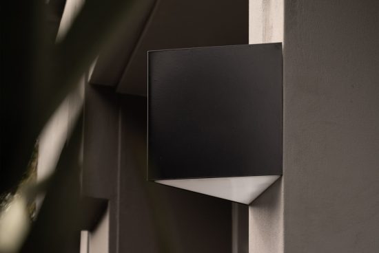 Minimalist black square wall lamp design mockup in an architectural setting, perfect for showcasing lighting design in a modern context.