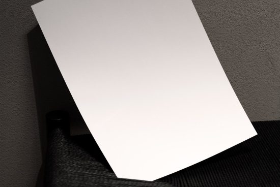 Blank white paper sheet mockup leaning on a textured wall with a subtle shadow, ideal for displaying designs or graphics.