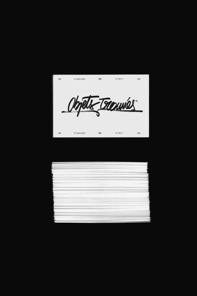 Business card mockup with elegant script font showcasing branding design on stacked paper cards against a dark background.