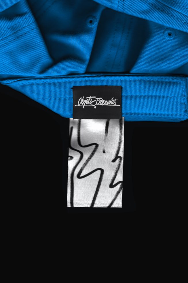 Close-up view of a blue shirt collar with a black and white label, ideal for fashion mockups and textile design presentations.