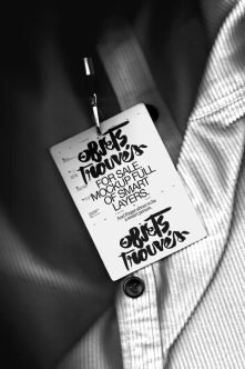 White flyer with bold black lettering on ribbed fabric background in black tone