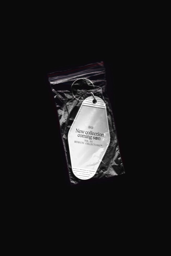 Fashion label tag mockup on a crinkled black bag, showcasing text for new collection announcement, ideal for designers creating realistic branding presentations.