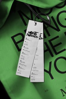Narrow hang tag on bright green fabric with bold black geometric letters
