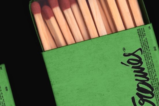 Close-up texture of a green matchbox with matches, ideal for realistic mockups, background graphics, and creative designs.