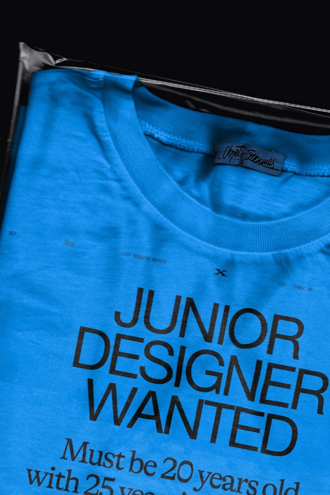 T-shirt mockup on hanger with bold text Junior Designer Wanted, ideal for design job ads, fashion and typography presentations.