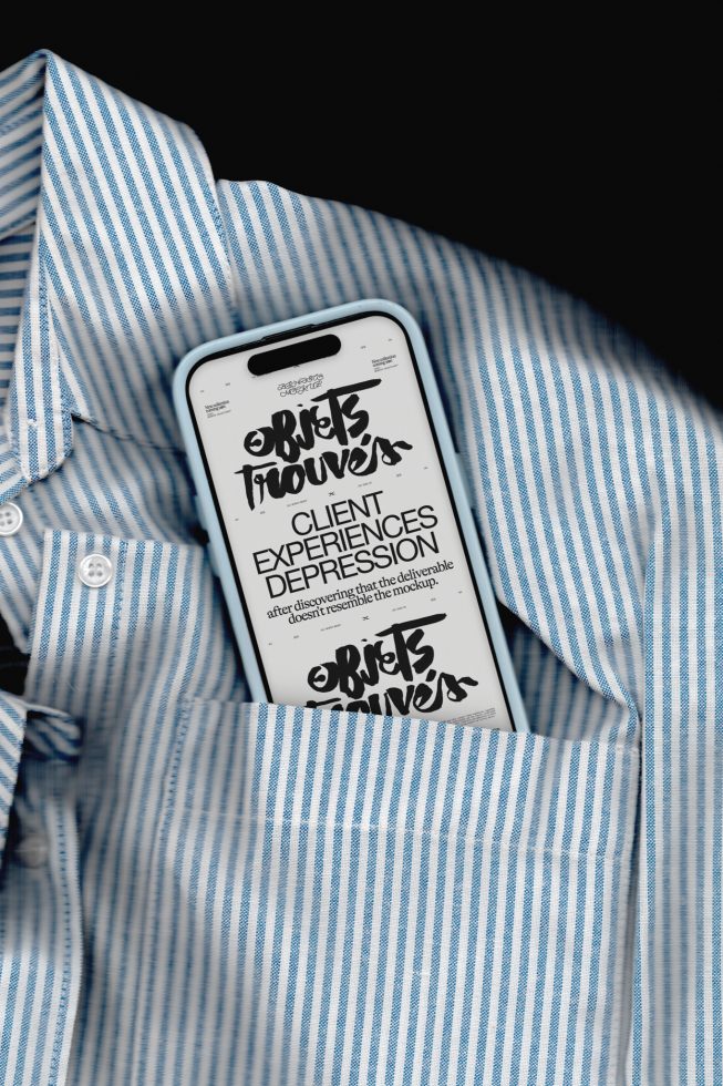 Smartphone with stylish graffiti font display on screen, nestled in blue striped shirt pocket, ideal for font mockup presentations.