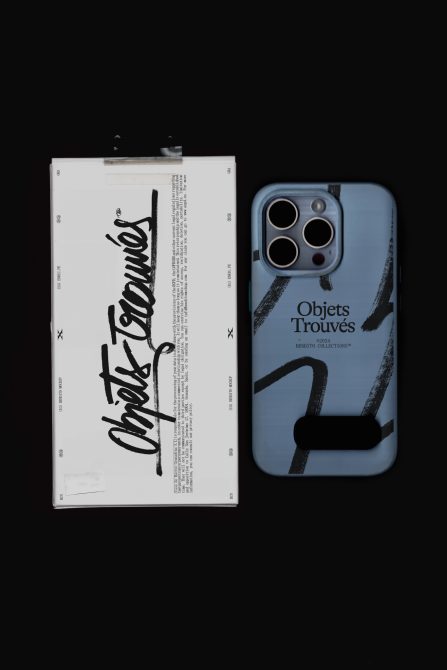 White box next to iPhone case in soft blue with black strap detail on dark background