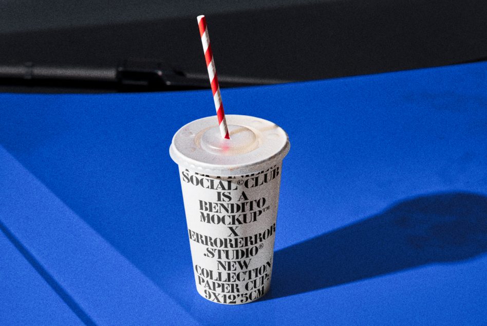 Paper cup with straw mockup on blue background, featuring editable design for graphic presentation. Ideal for digital asset portfolio showcase.