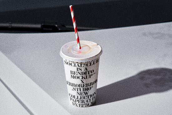 Paper cup mockup with retro typography and striped straw on textured surface, ideal for branding and packaging design.