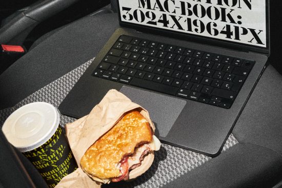 Laptop with distorted text on screen next to a burger and coffee cup on a car seat, suitable for graphic design mockups.