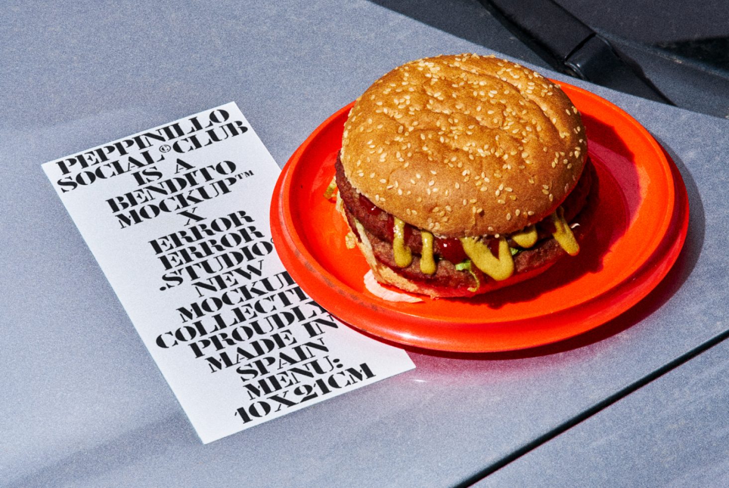 Stylized food mockup featuring a juicy burger on a red plate with a bold font menu design for creative template showcase.