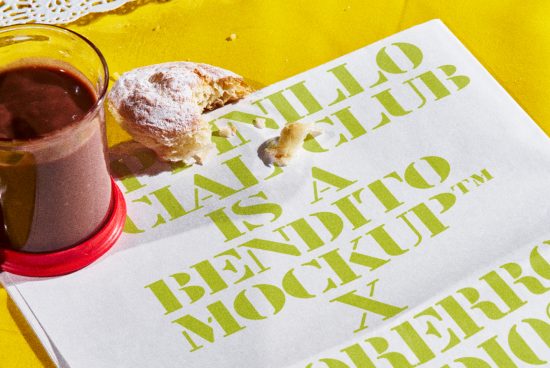 Stylized typographic mockup with bold green font on a crumpled paper, accented by a half-eaten pastry and glass of chocolate milk on a yellow surface.