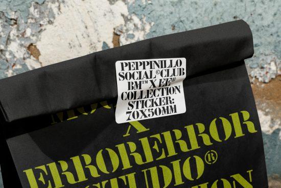 Sticker mockup on folded black fabric with typographic design, showcasing label presentation for fashion and design assets.
