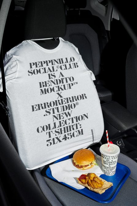 White t-shirt mockup on car seat with burger, fries, cup in front, black text design