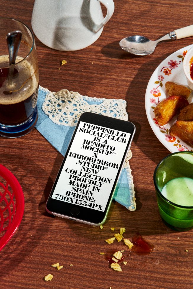 Smartphone mockup on table with coffee, pot, snacks, displaying typographic design, ideal for app interface and web design mockups.