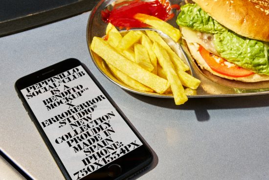 Smartphone mockup displaying bold typography beside a burger and fries on a plate, ideal for showcasing design work and fonts.