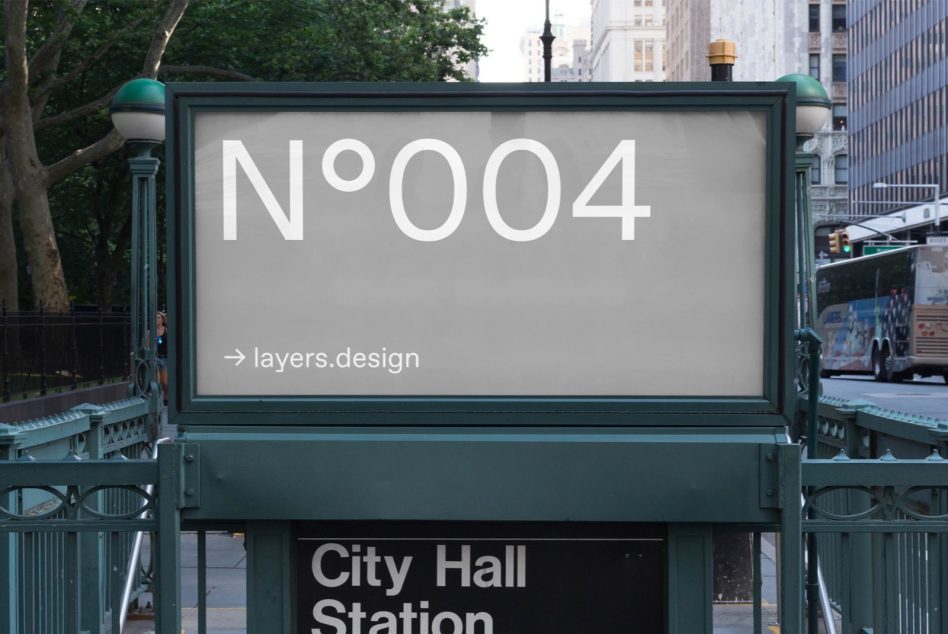 Teal framed City Hall Station sign displaying N°004 overlooking busy urban street