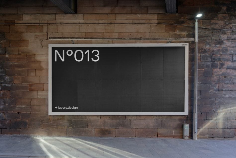 Dark billboard mockup labeled N°013 on textured brick industrial wall