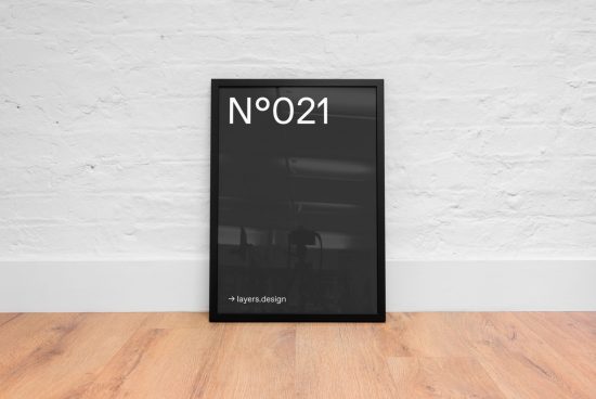 Minimalist poster Mockup in black frame against white brick wall on wooden floor for design display.