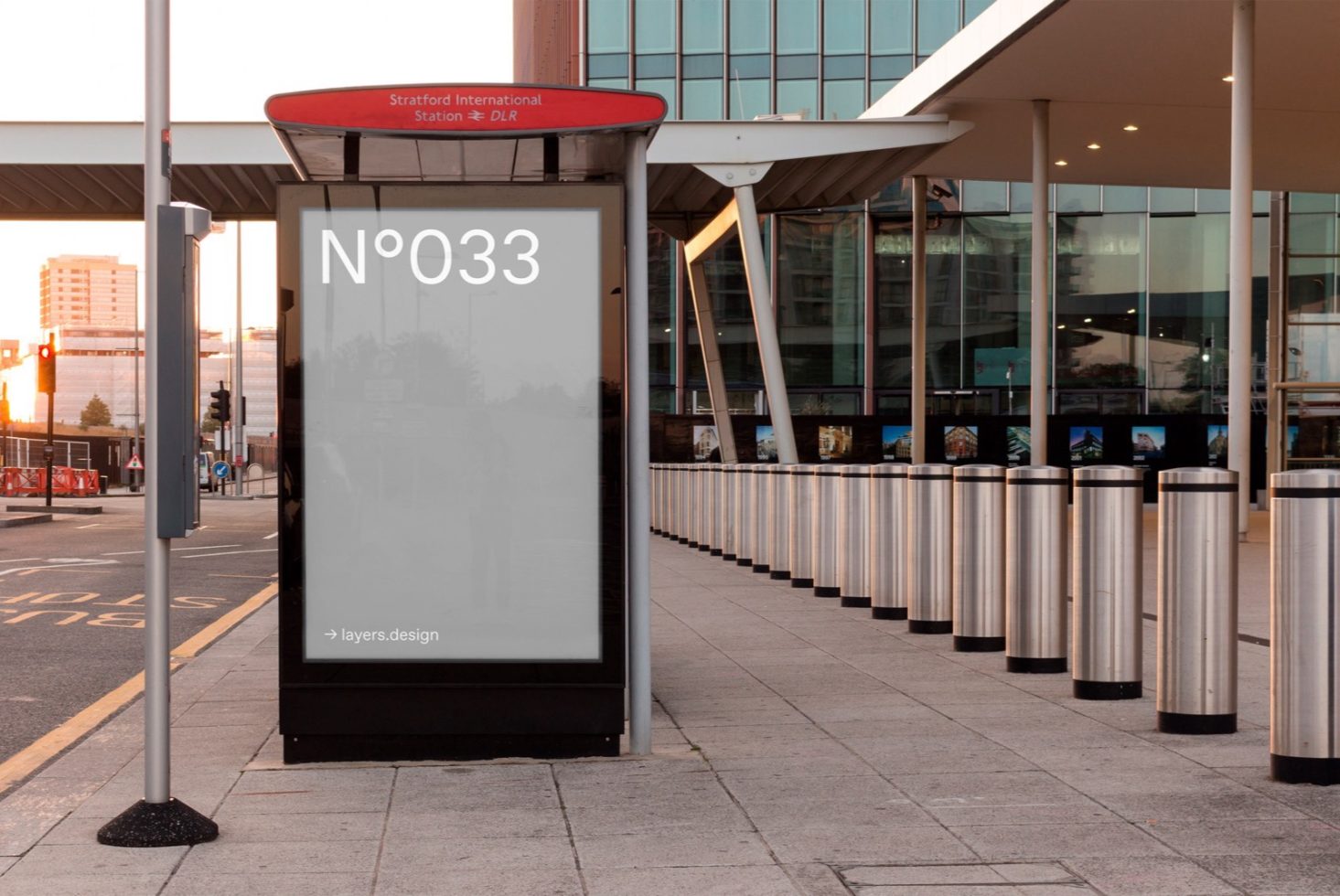 Urban bus stop billboard mockup at Stratford International Station with clear sky, ideal for advertising and design presentations in outdoor settings.