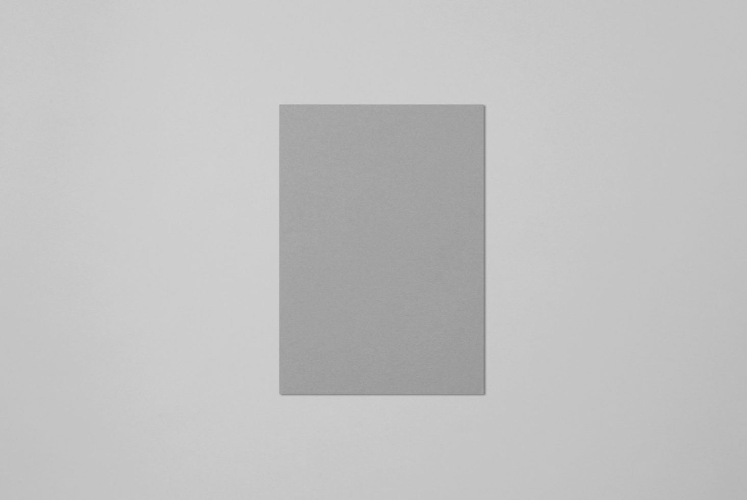 Blank vertical paper card mockup with shadow on a light grey background, ideal for design presentations and branding.