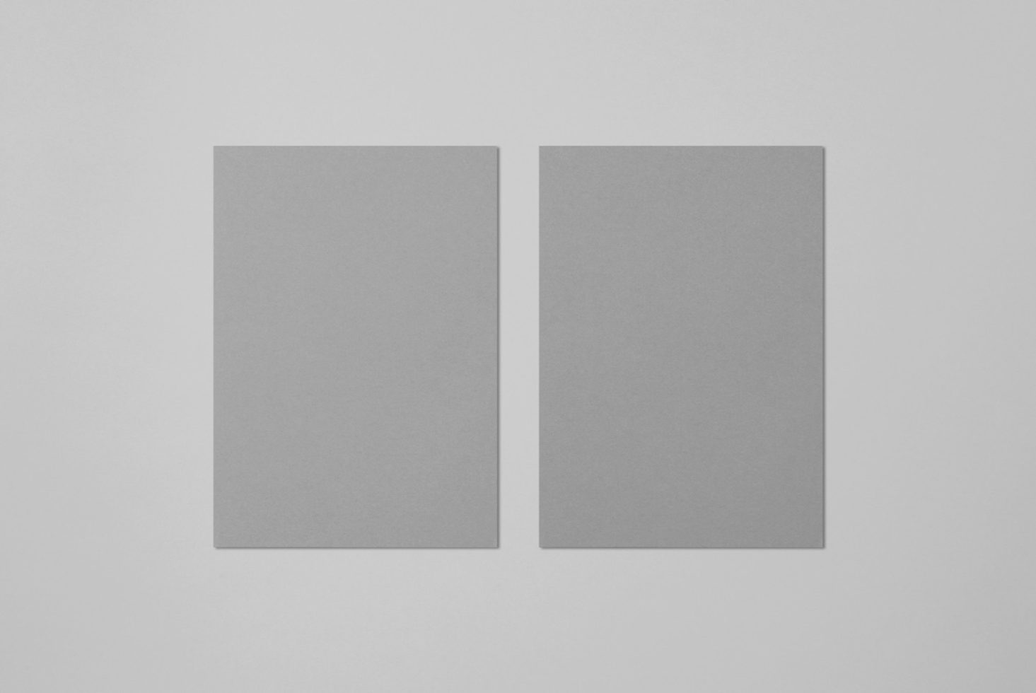 Two blank paper sheets mockup on a plain background, ideal for clean and minimalistic design presentations, easily editable for graphic designers.