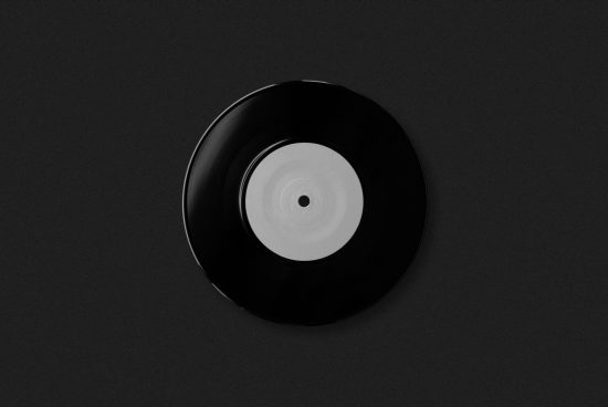 Vinyl record mockup on dark background for music-related graphic design. Perfect for showcasing album artwork or label designs.