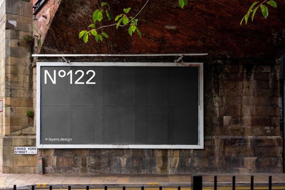 Dark charcoal storefront billboard on aged brick wall with white frame border