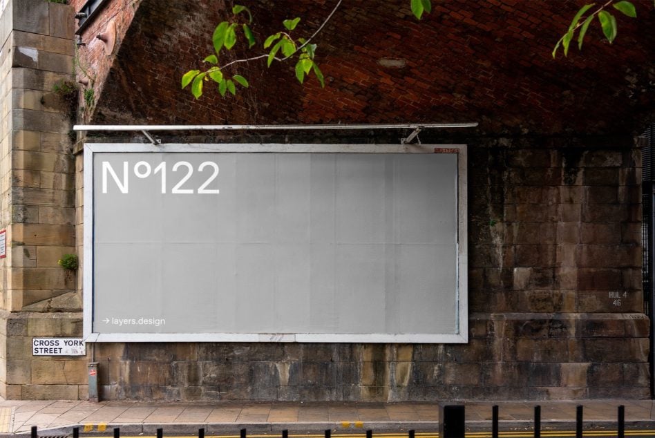 Light gray storefront billboard on weathered brick wall with white frame border
