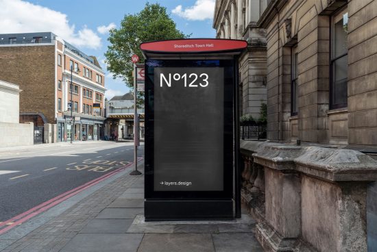 Urban bus stop mockup with blank advertisement space beside Shoreditch Town Hall, ideal for showcasing design projects in a realistic setting.