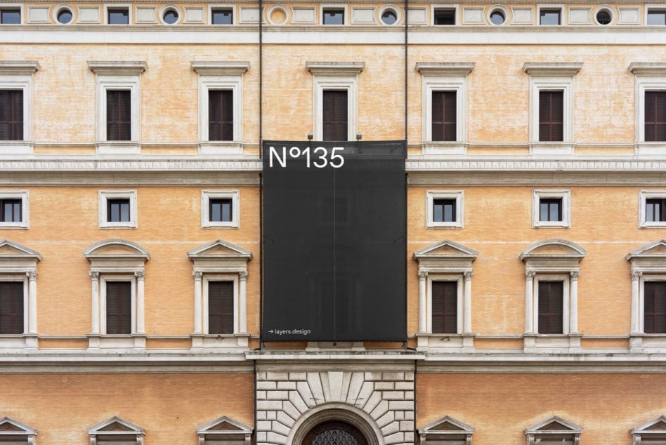 Dark vertical banner N°135 mounted on ornate classical building exterior