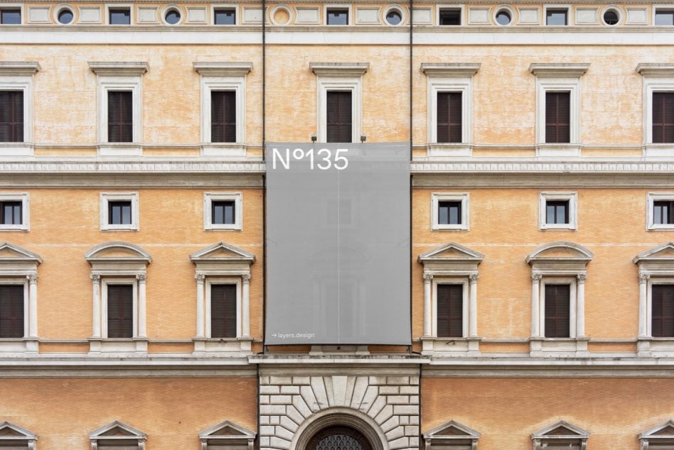 Vertical grey banner N°135 on classical yellow brick building facade