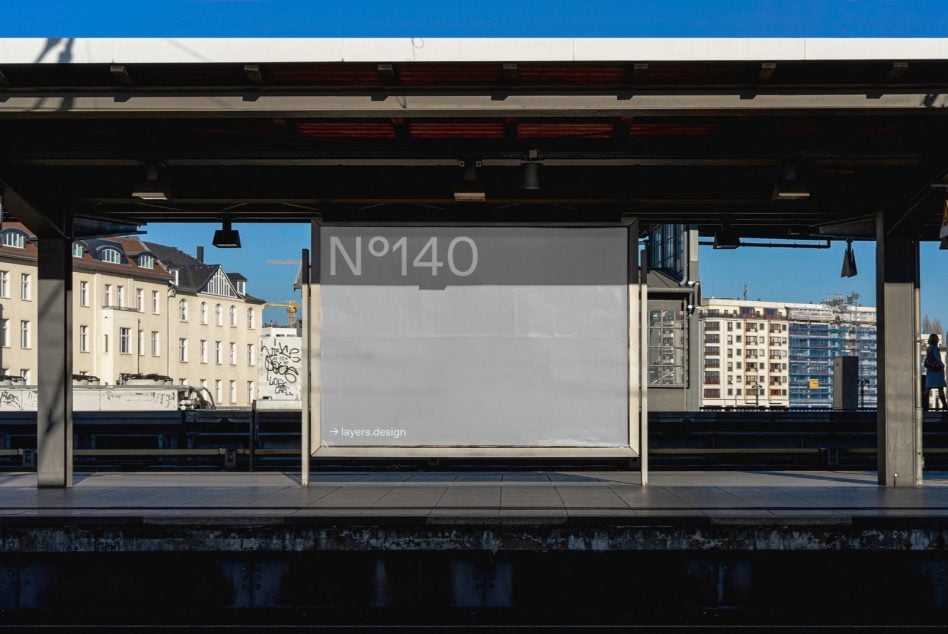 Gray transit shelter billboard N°140 on subway platform with city views