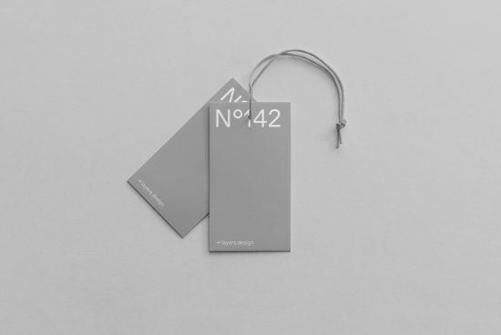 Minimalistic clothing tag mockup on a gray background, showcasing sleek design for branding, ideal for designer product presentations.