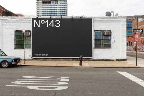 Urban billboard mockup on white brick wall beside street with vintage car, ideal for designers to display advertising graphics.