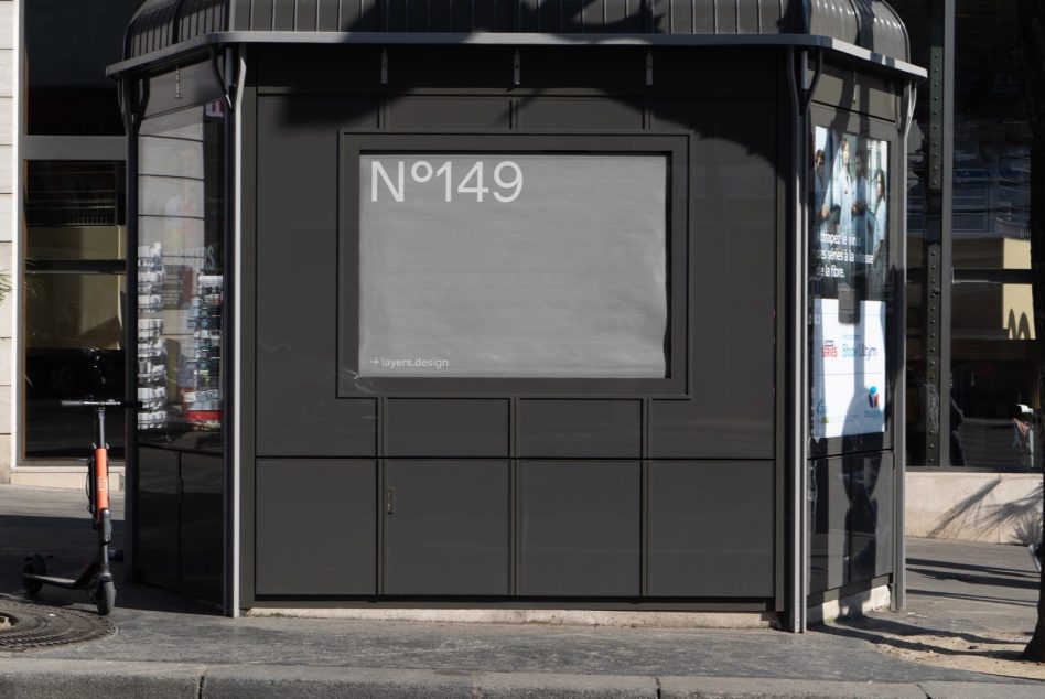 Urban street kiosk mockup with blank advertising billboard for poster design presentation, situated in a real-life city context for realistic mockup graphics.