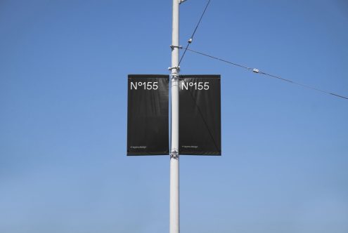 Outdoor banner mockup on a light pole with clear blue sky, showcasing minimalist design for advertising, ideal for designers and templates.