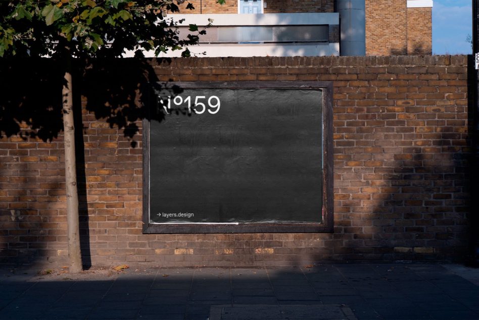 Dark street billboard on textured brick with foliage shadow