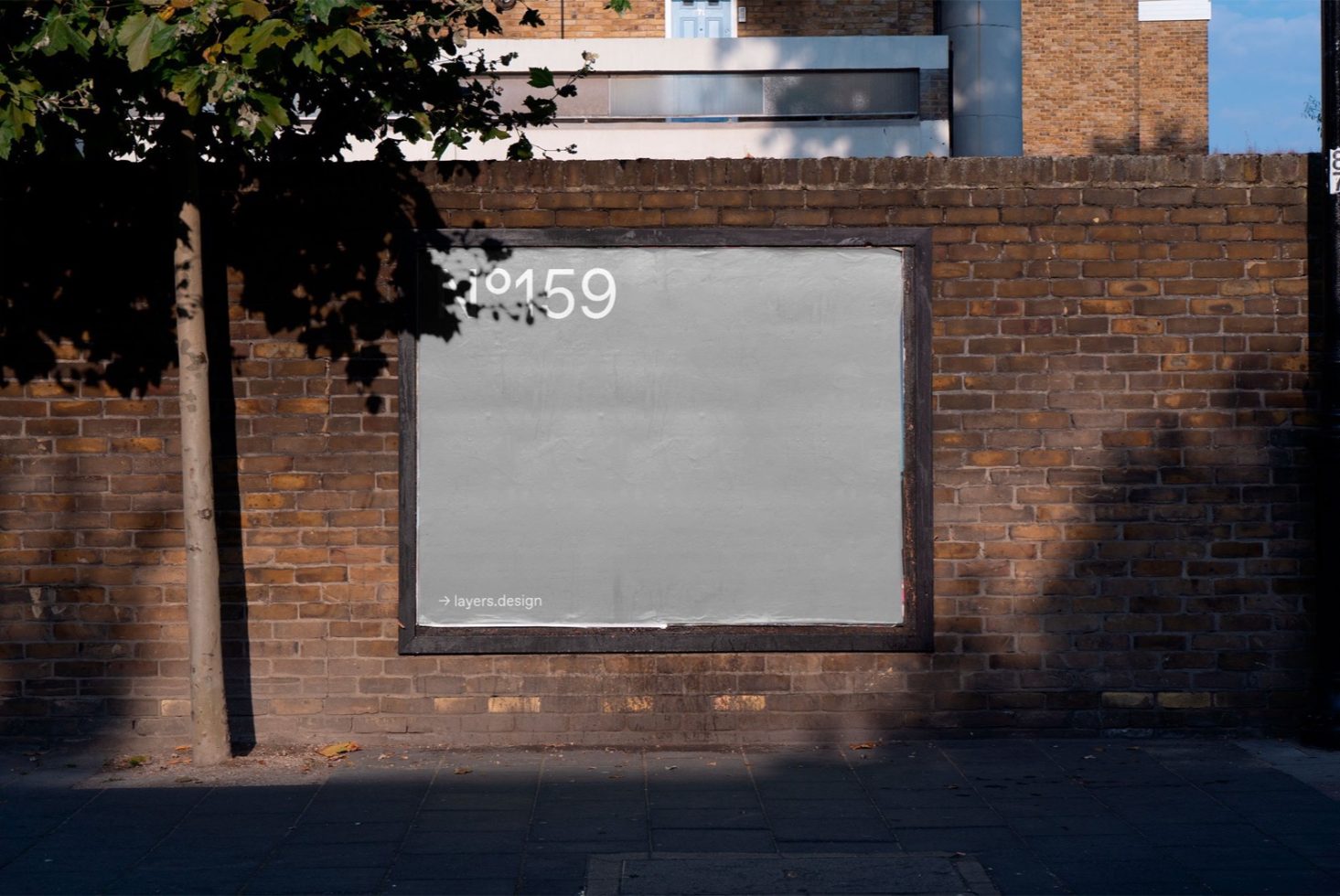 Urban brick wall with blank billboard mockup for advertising design presentation, clear sunny day, space for text graphics.