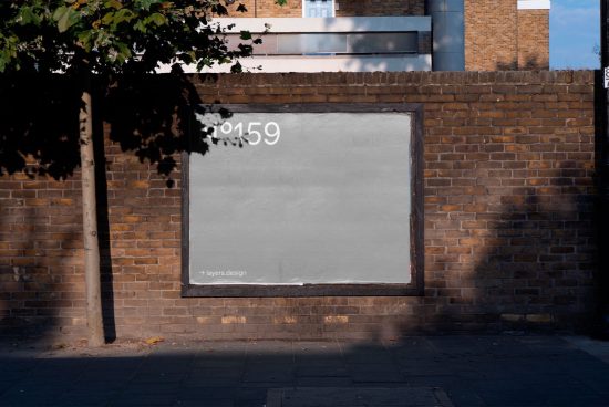 Urban brick wall with blank billboard mockup for advertising design presentation, clear sunny day, space for text graphics.