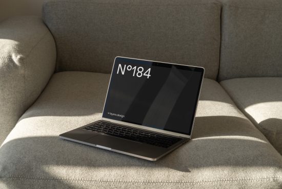 Laptop with minimalist screen mockup on cozy sofa in natural light, ideal for showcasing web design and UI/UX projects.