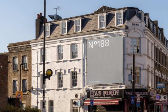 Urban billboard mockup on building corner with clear sky, ideal for advertising design presentation, suitable for designers looking for realistic urban templates.