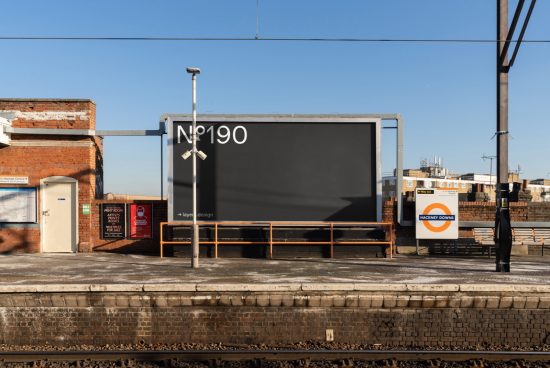 Blank billboard mockup at a train station, clear blue sky, urban setting, ideal for advertising designs, digital asset for graphic designers.