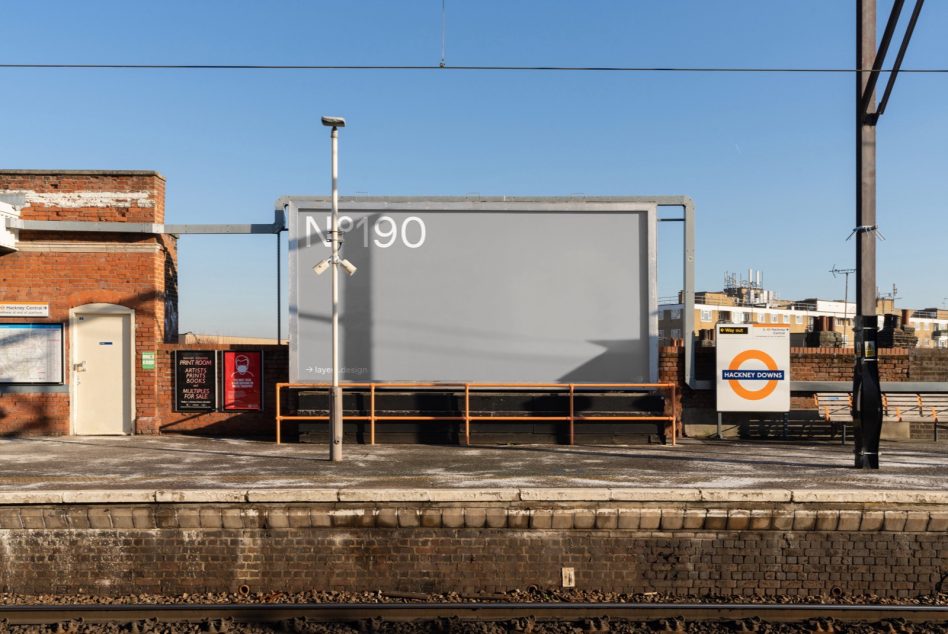 Billboard mockup at train station platform with clear sky, ideal for advertising, poster design presentation and urban marketing graphics.