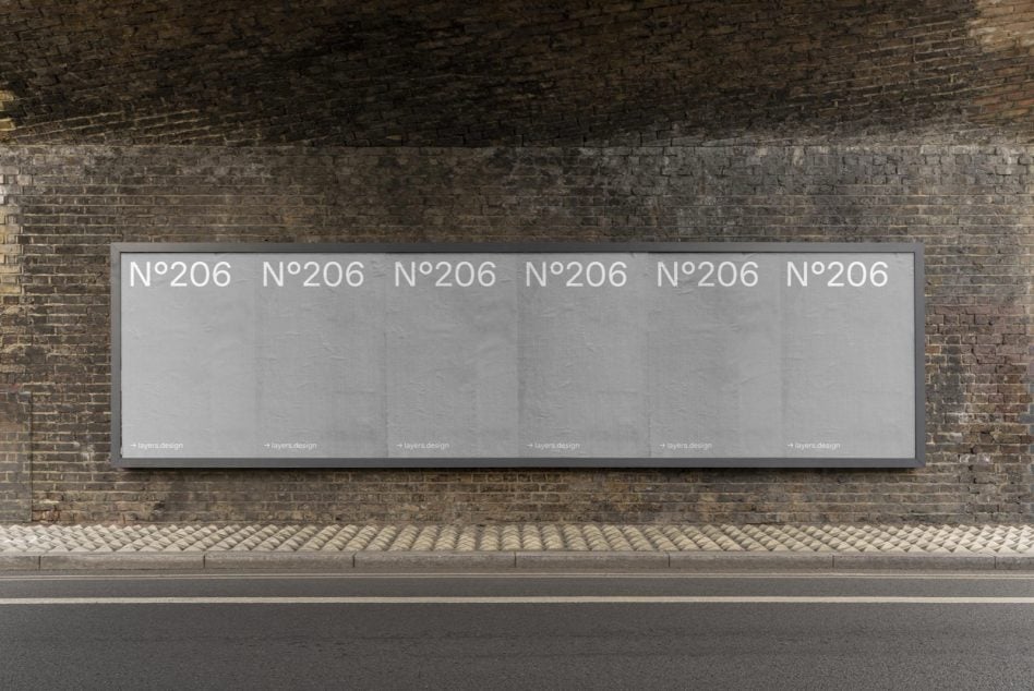 Long horizontal billboard on weathered brick wall with light gray background, N°206