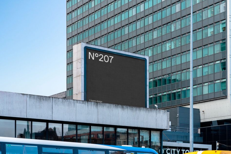 Rooftop billboard with blue frame on modern glass building, displaying N°207
