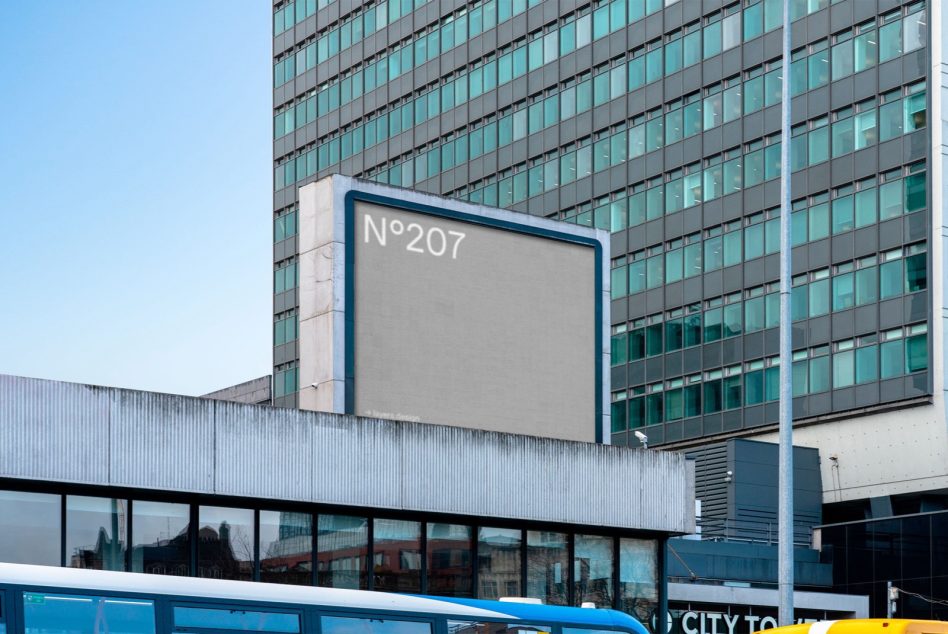 Rooftop N°207 sign on modern office tower with glass high-rise behind it