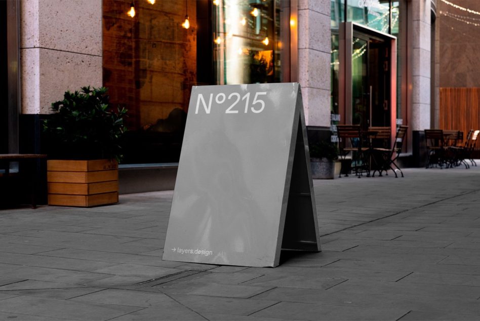 Urban street signage mockup in an outdoor setting, showcasing a customizable sandwich board design with a modern aesthetic for ads and branding.