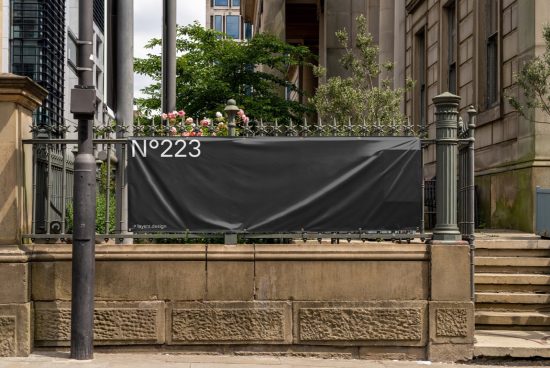 Urban billboard mockup on a wrought iron fence with city backdrop for outdoor advertising design presentations.
