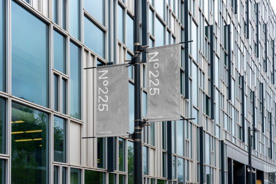 Urban flag mockup hanging on a modern building facade with reflective glass windows perfect for showcasing design work to clients